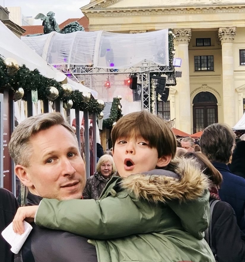 Elliot carrying a young boy at a European Christmas market